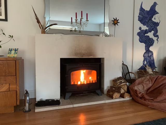 A wood-burning stove fitted in a home fireplace